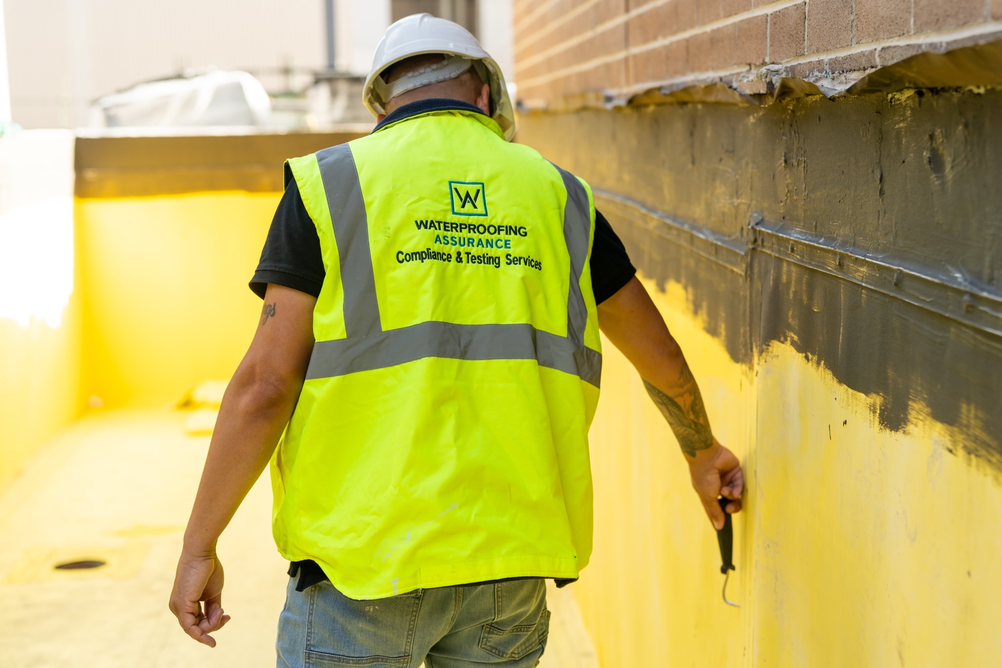 A man wearing a waterproof yellow vest.