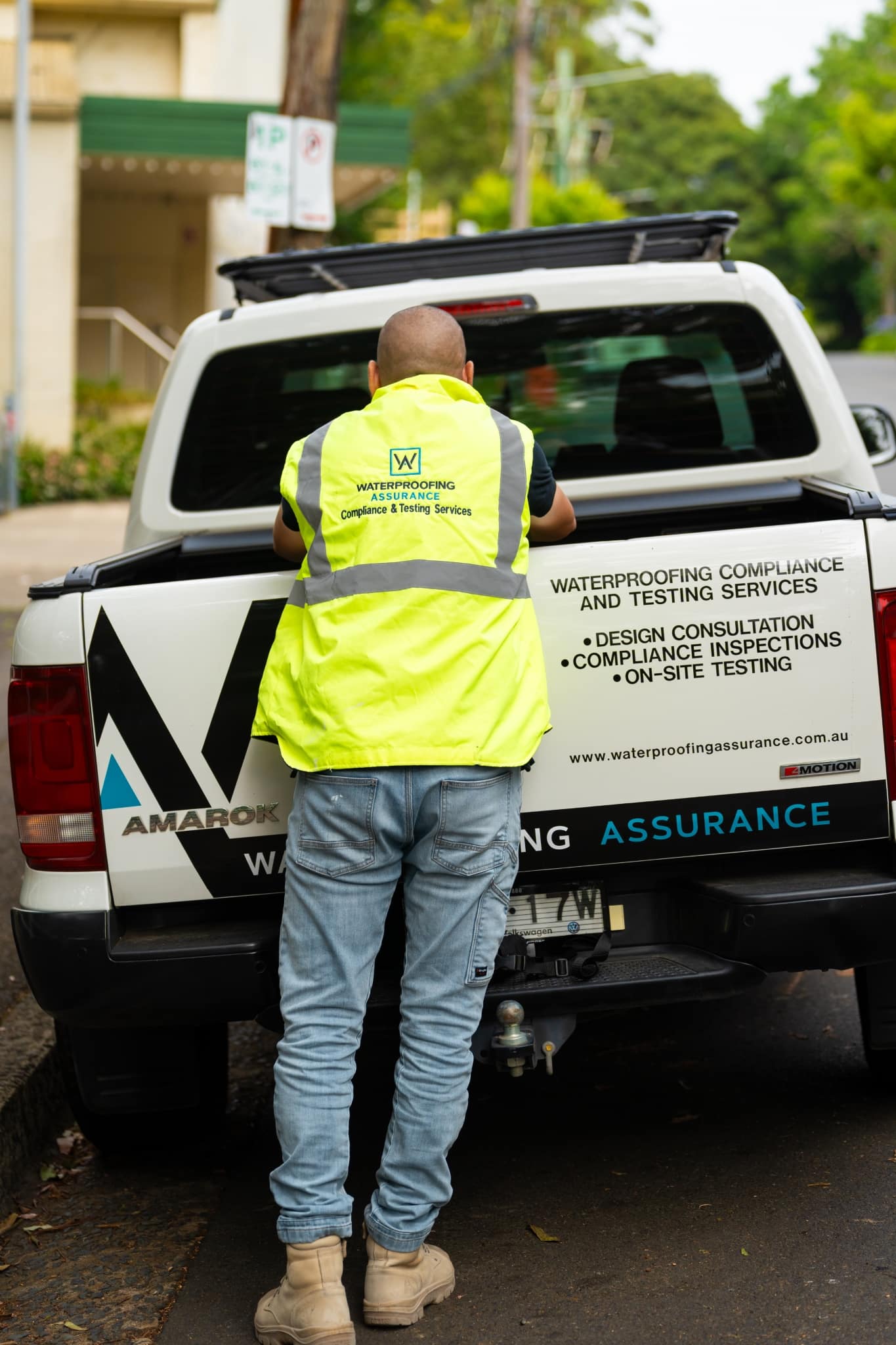 A man standing next to a waterproofing truck.