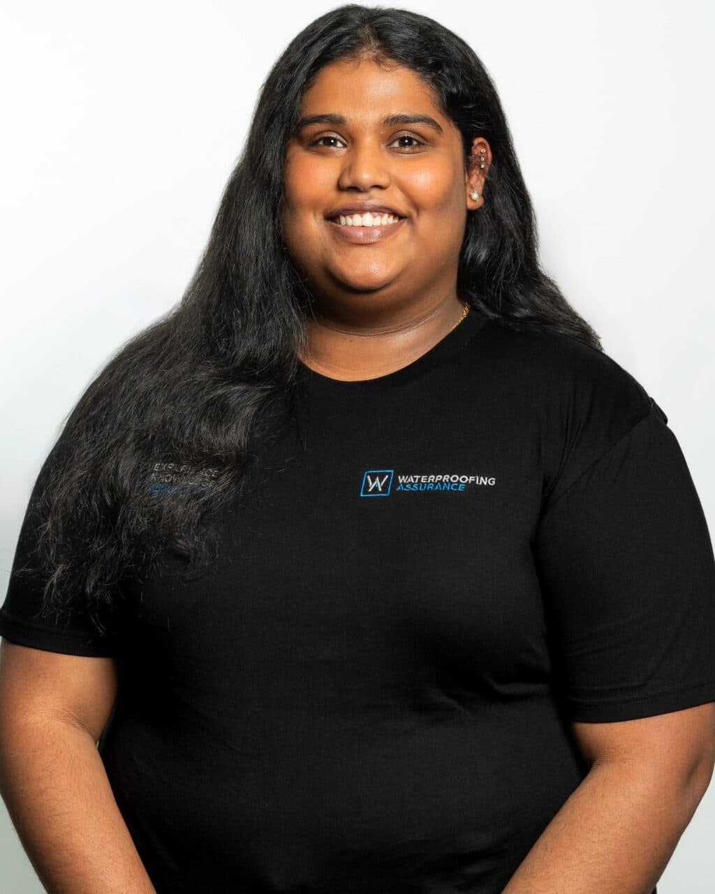 Person smiling, wearing a black t-shirt with a "Waterproofing Insurance" logo.